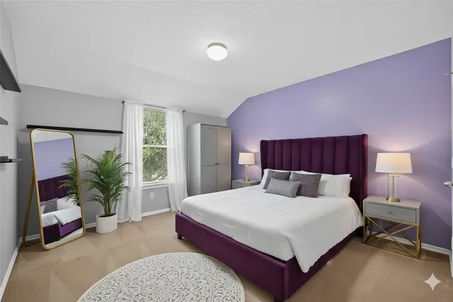 a bedroom with a large bed and a potted plant