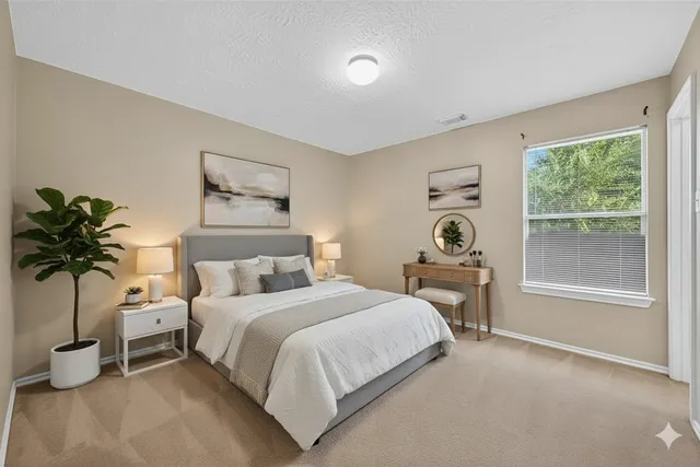 a bedroom with a bed and a potted plant