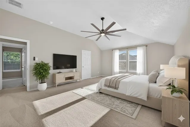 a bedroom with a large bed and a flat screen tv