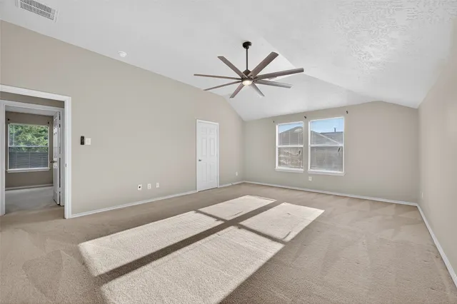 an empty room with windows and fan