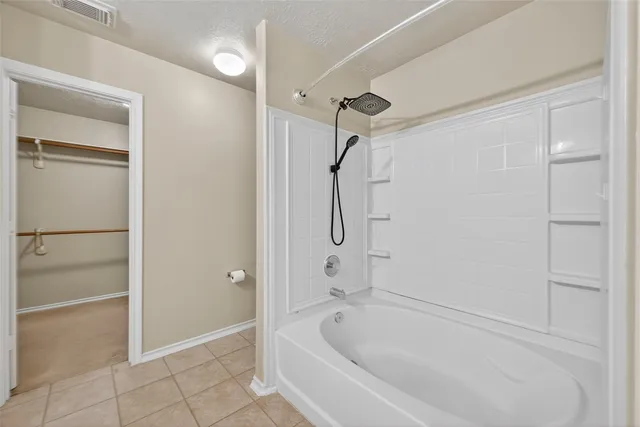 a white bath tub sitting next to a shower
