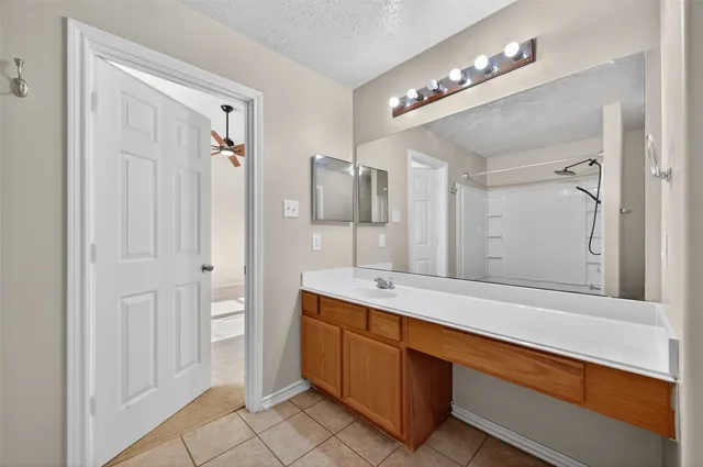 a spacious bathroom with a sink a large mirror and a shower