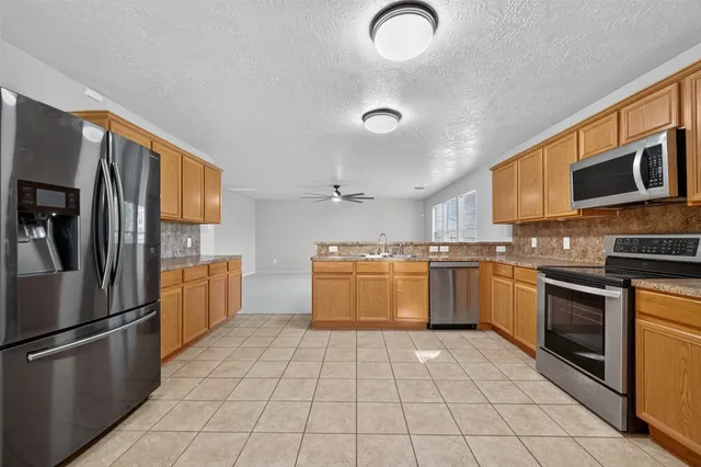 a kitchen with stainless steel appliances granite countertop a stove top oven a sink and dishwasher