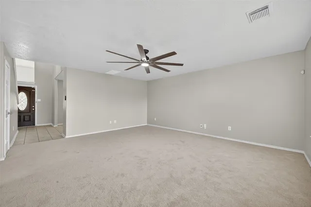 a view of a livingroom with a ceiling fan and wooden floor