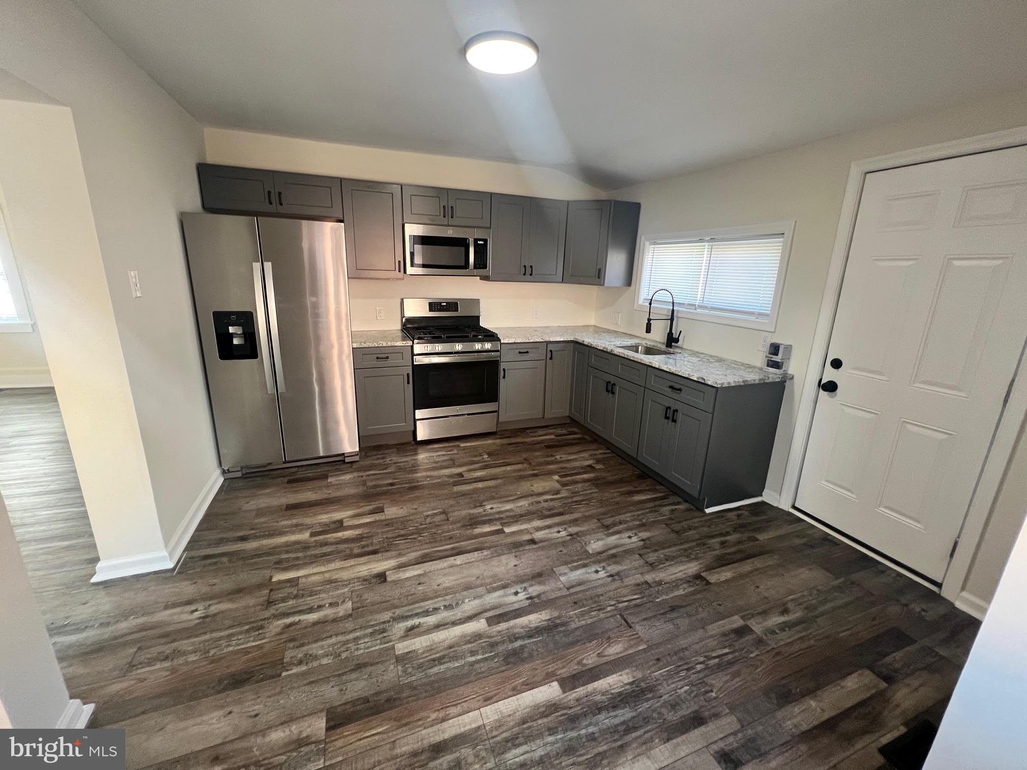 107 Church Street, Unit B Glassboro, NJ 08028 - Photo 5 of 9 a large kitchen with a refrigerator and a stove top oven