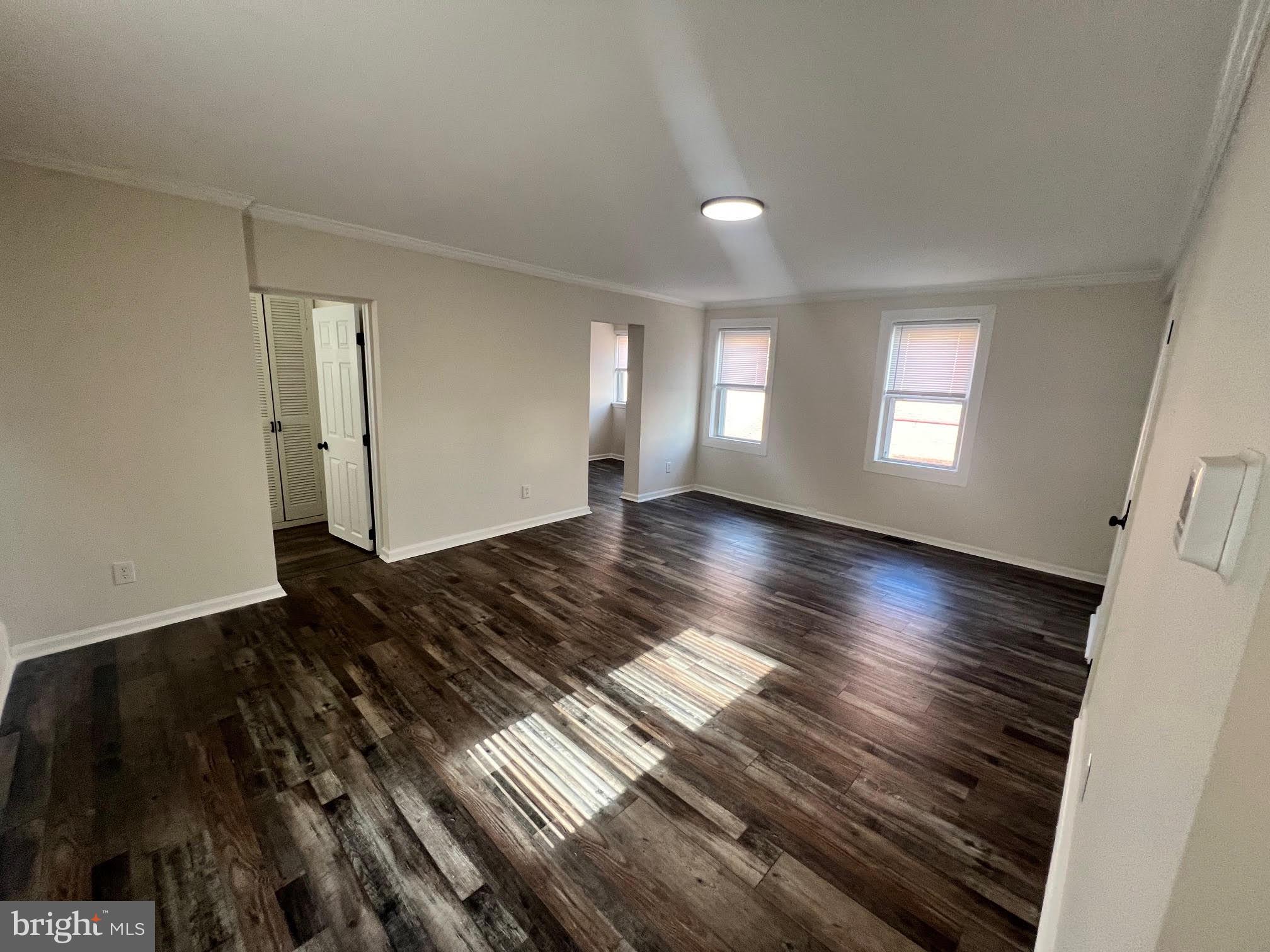 107 Church Street, Unit B Glassboro, NJ 08028 - Photo 6 of 9 a view of an empty room with wooden floor and a window