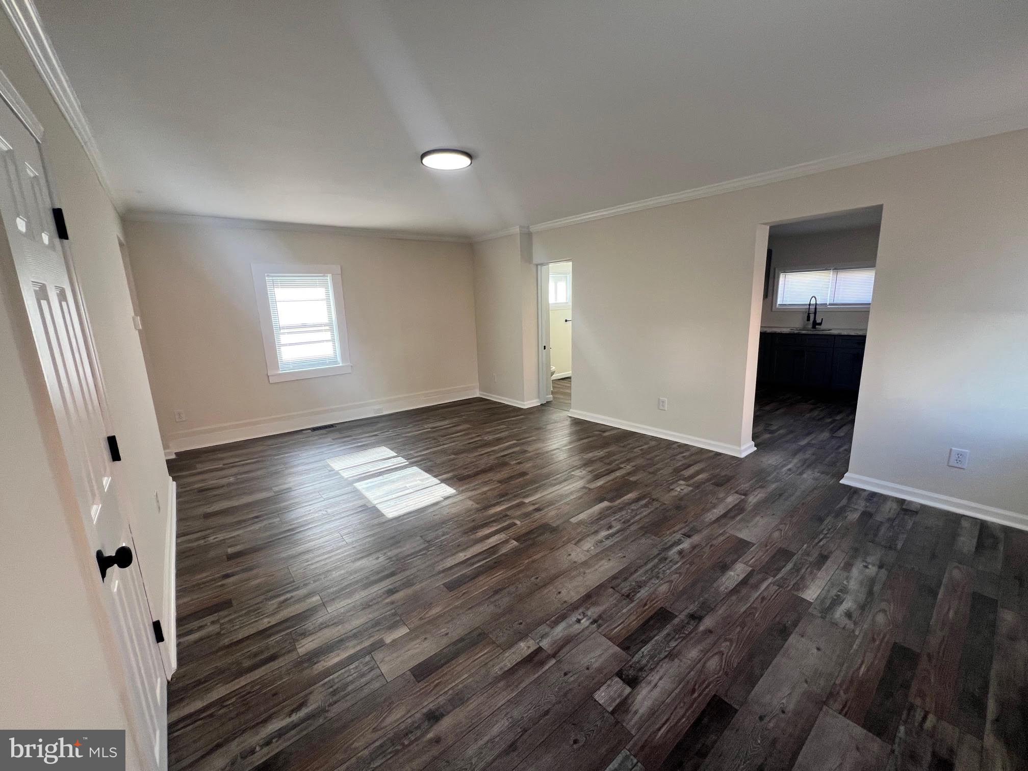 107 Church Street, Unit B Glassboro, NJ 08028 - Photo 7 of 9 an empty room with wooden floor and windows