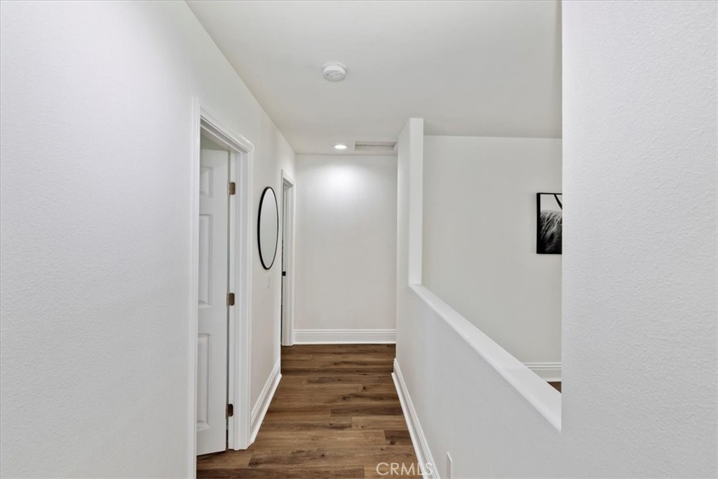 19594 Temescal Canyon Road Corona, CA 92881 - Photo 41 of 50 a view of a hallway with wooden floor and staircase