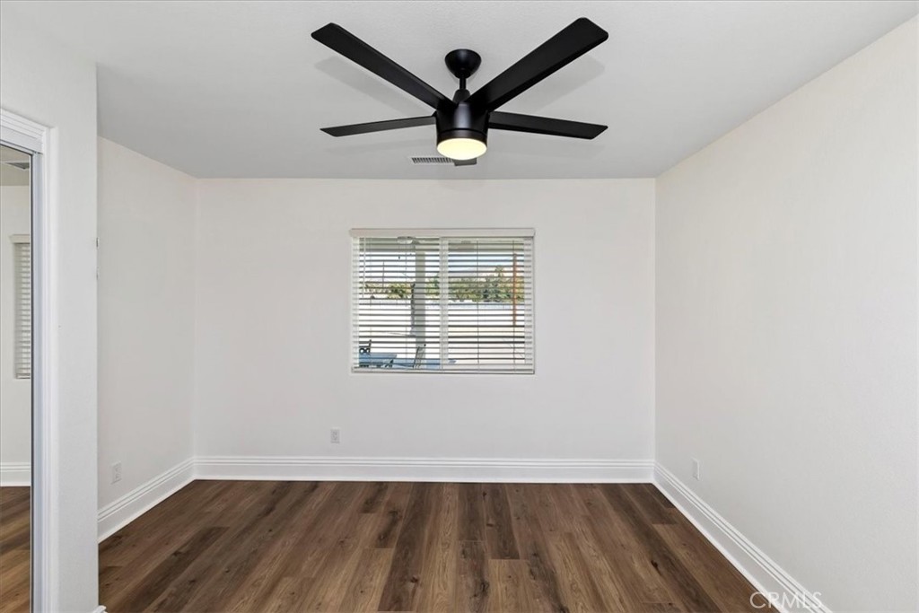 19594 Temescal Canyon Road Corona, CA 92881 - Photo 43 of 50 an empty room with wooden floor and windows