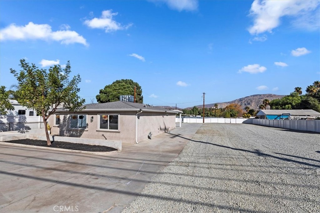 19594 Temescal Canyon Road Corona, CA 92881 - Photo 9 of 50 a view of a white house with a yard