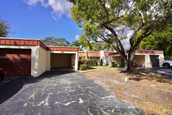 a view of a house with backyard and a tree