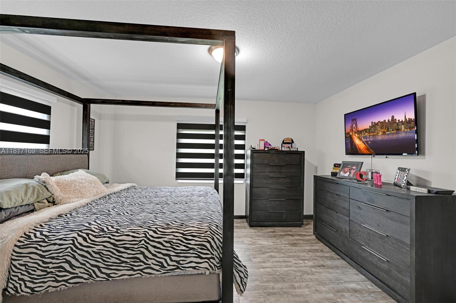30930 Southwest 190th Avenue Homestead, FL 33030 - Photo 16 of 36 a bedroom with a bed and a flat screen tv