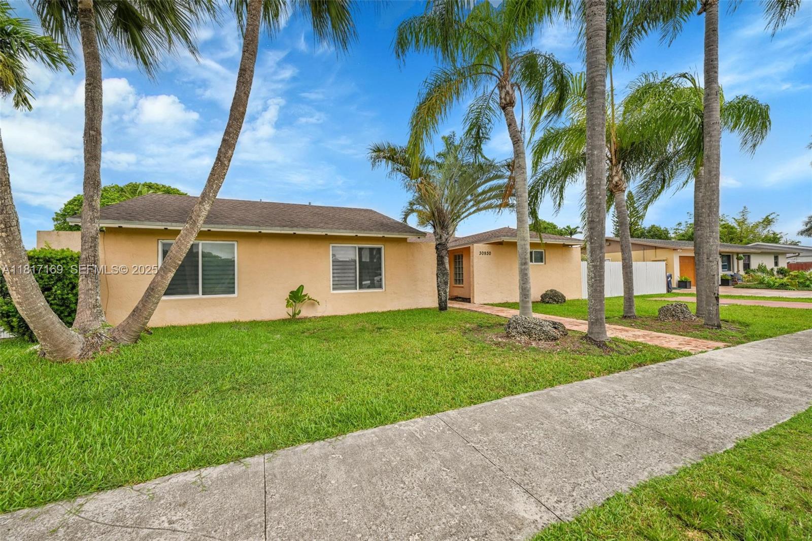 30930 Southwest 190th Avenue Homestead, FL 33030 - Photo 2 of 36 a front view of a house with a garden and yard