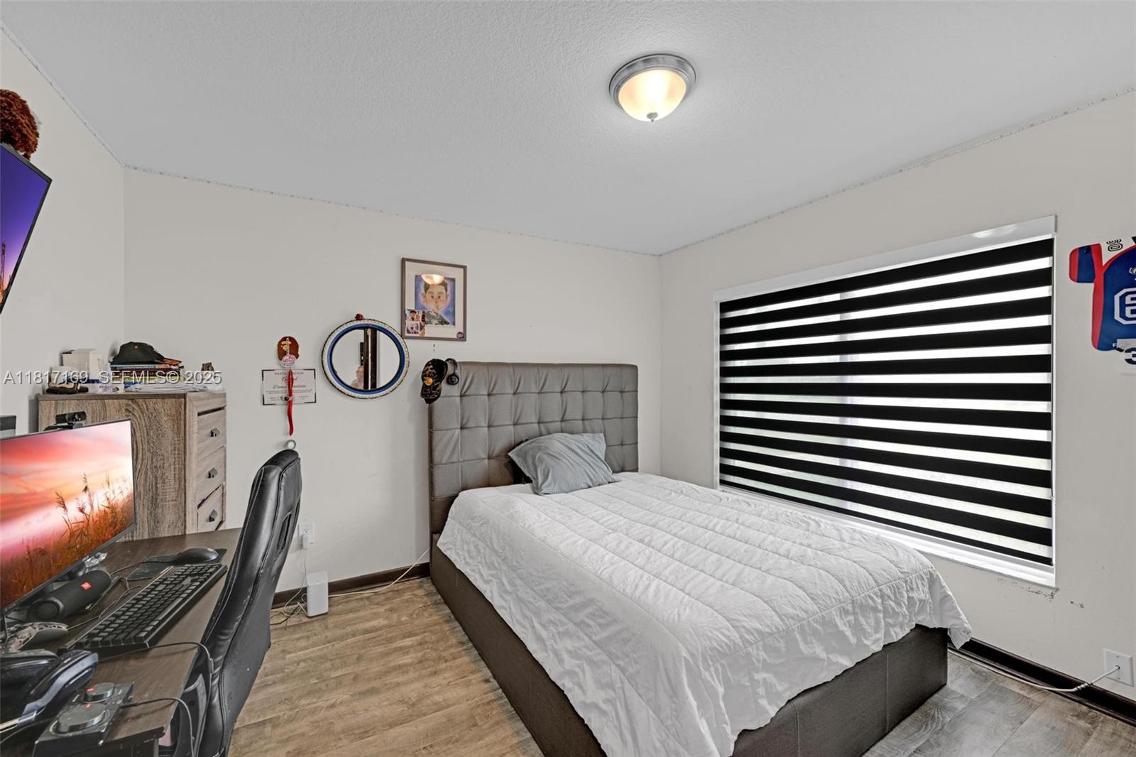 30930 Southwest 190th Avenue Homestead, FL 33030 - Photo 21 of 36 a bedroom with a bed and a flat tv screen on the dresser