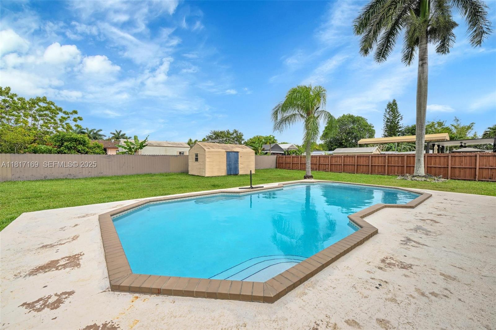 30930 Southwest 190th Avenue Homestead, FL 33030 - Photo 30 of 36 a view of a swimming pool with a yard and palm trees