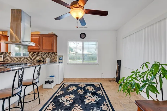 a kitchen with stainless steel appliances granite countertop a sink a stove a table and chairs