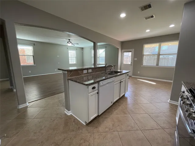 a kitchen with stainless steel appliances granite countertop a stove a sink and a microwave