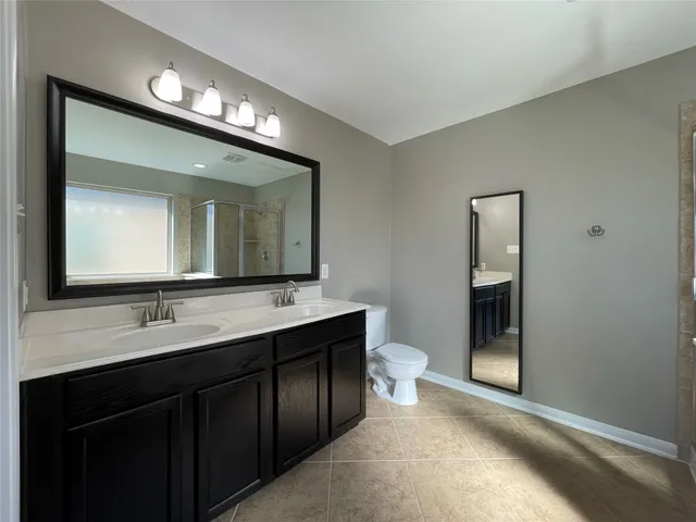 a en suite bathroom with a double vanity sink and a large mirror