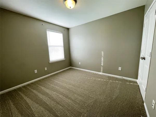 an empty room with a window and a ceiling fan