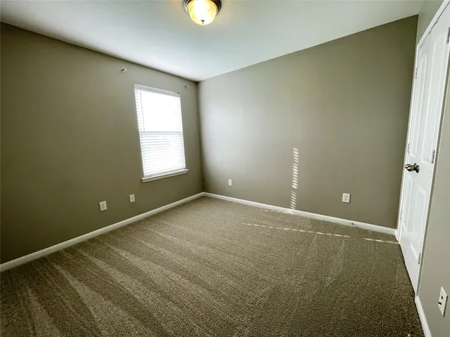 an empty room with a window and a ceiling fan