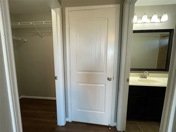 an empty room with wooden floor chandelier fan and windows