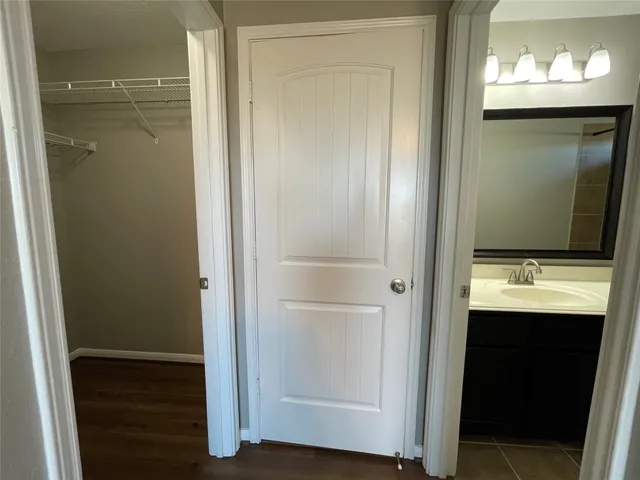 an empty room with wooden floor chandelier fan and windows