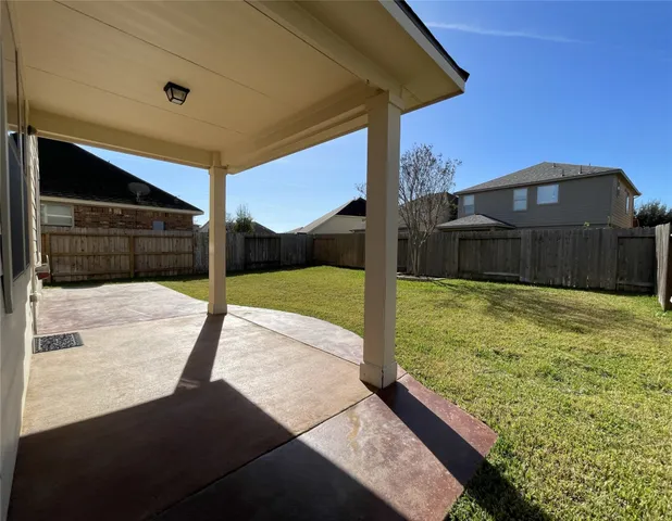 an empty room with wooden floor and fan