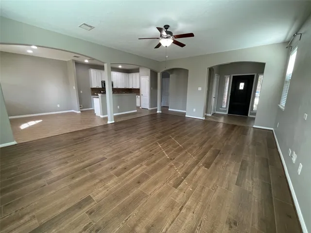 a view of empty room with wooden floor and windows