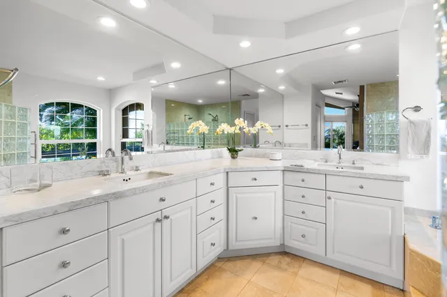 a bathroom with a granite countertop sink mirror and window