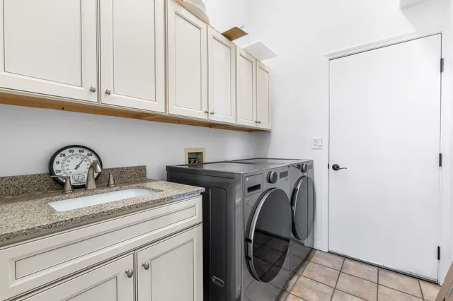 a utility room with granite countertop a sink and a washer dryer
