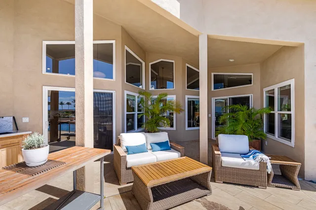 a view of a patio with couches table and chairs and potted plants