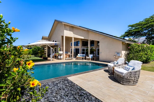 a view of a house with swimming pool and sitting area