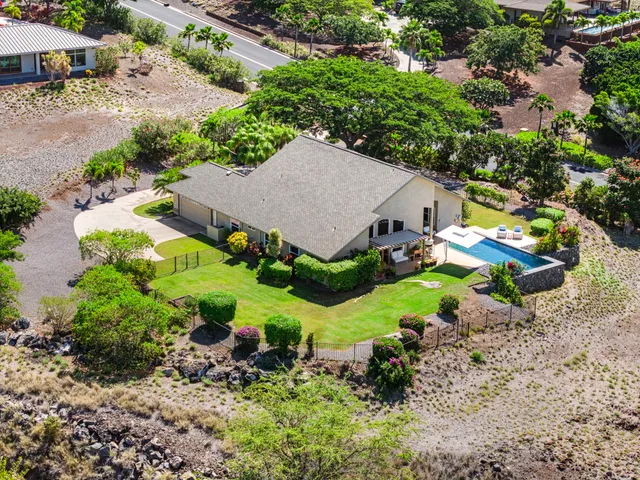 an aerial view of a house with a garden and swimming pool