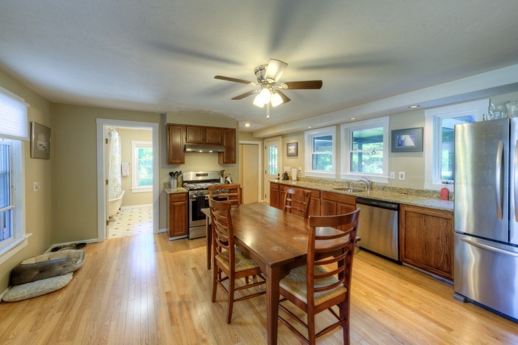 167 Worcester Street Grafton, MA 01536 - Photo 26 of 42 a dining room with stainless steel appliances granite countertop furniture wooden floor and a kitchen view