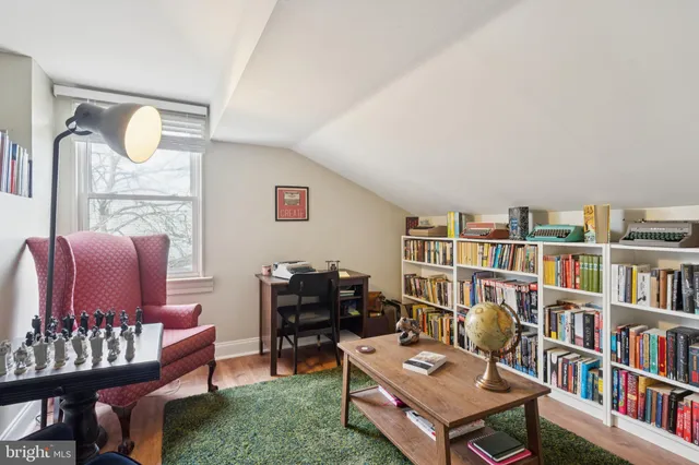 a living room with furniture a bookshelf and a book shelf