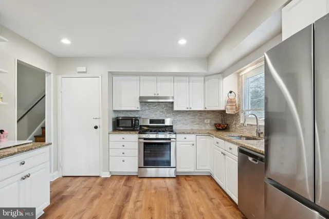 a kitchen with stainless steel appliances granite countertop a stove a sink and a refrigerator