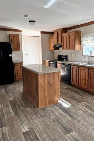 a kitchen with stainless steel appliances granite countertop a stove a sink dishwasher and a refrigerator