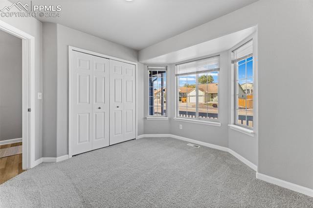 7515 Farmcrest Road Colorado Springs, CO 80925 - Photo 20 of 40 Bedroom with carpet flooring and a closet