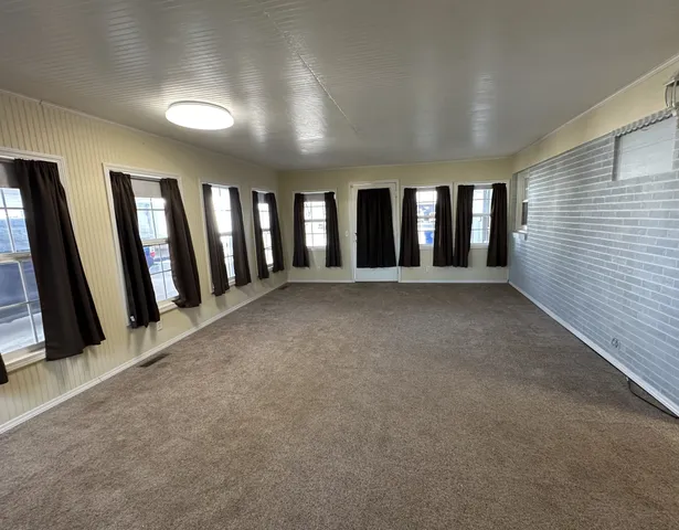 an empty room with windows and stairs