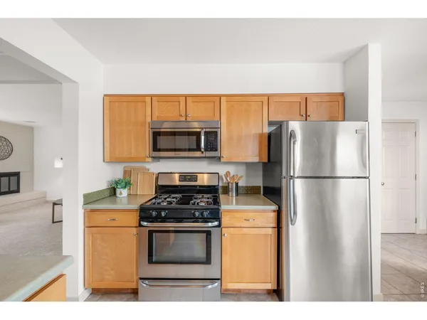 a kitchen with a refrigerator a stove a microwave and cabinets