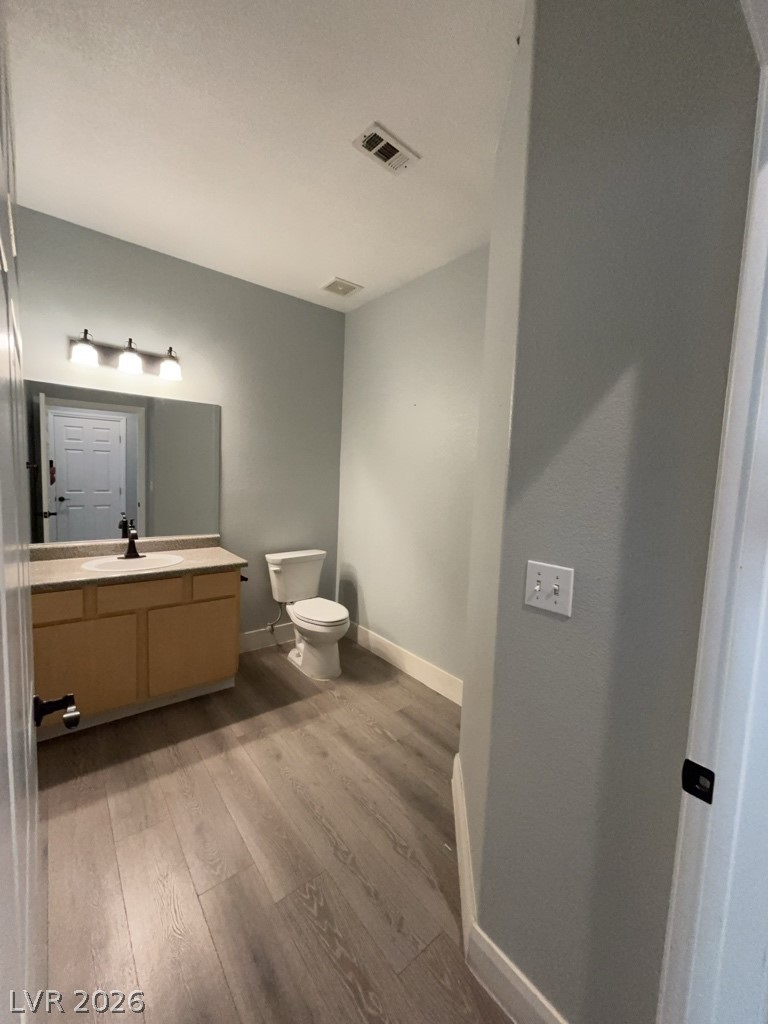 4915 East Russell Road, Unit 133 Las Vegas, NV 89120 - Photo 4 of 10 Wood flooring and a vanity with a mirror create a functional powder room.