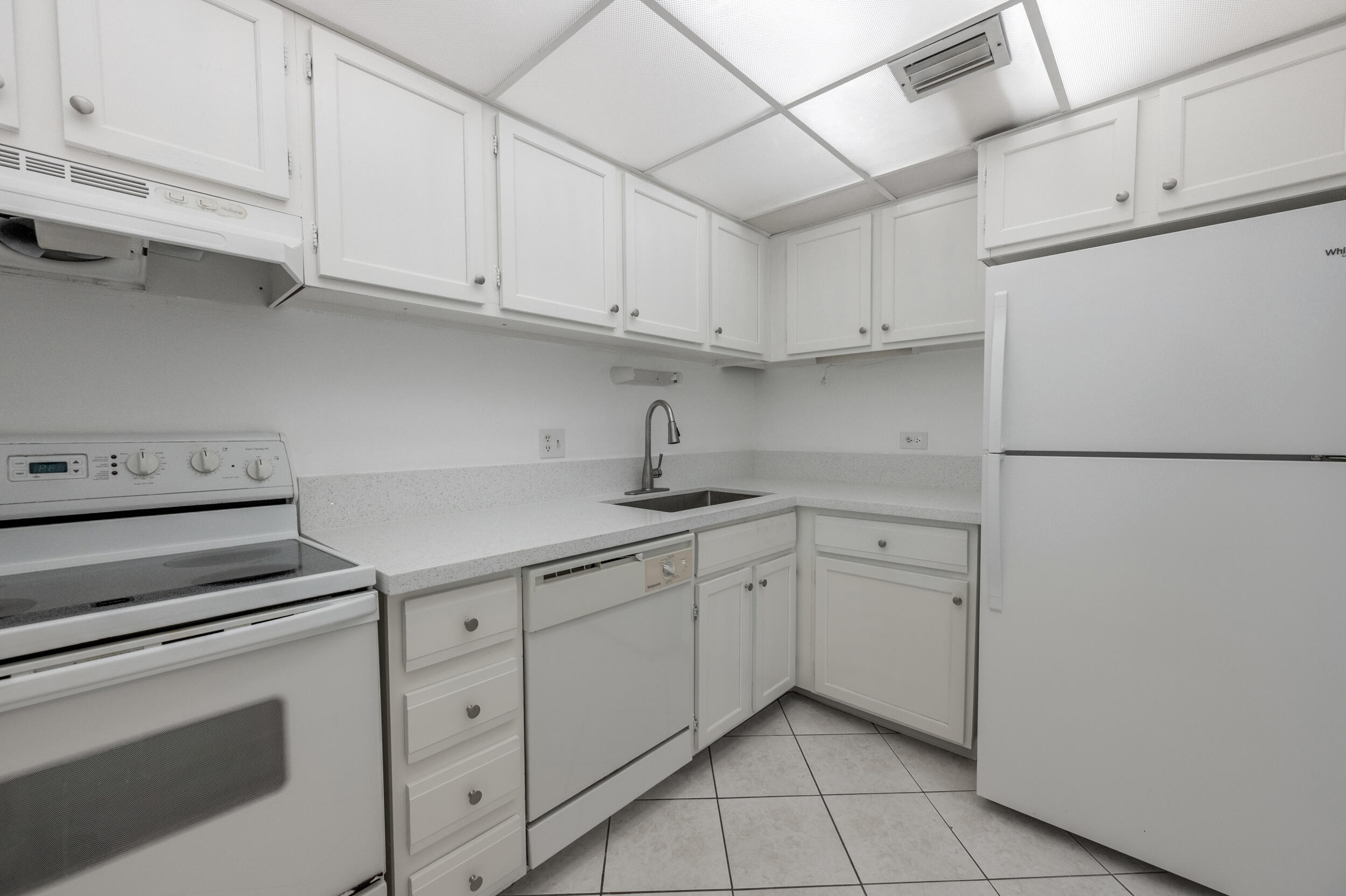 3660 Inverrary Drive, Unit 3Q Lauderhill, FL 33319 - Photo 13 of 35 a kitchen with white cabinets and white appliances