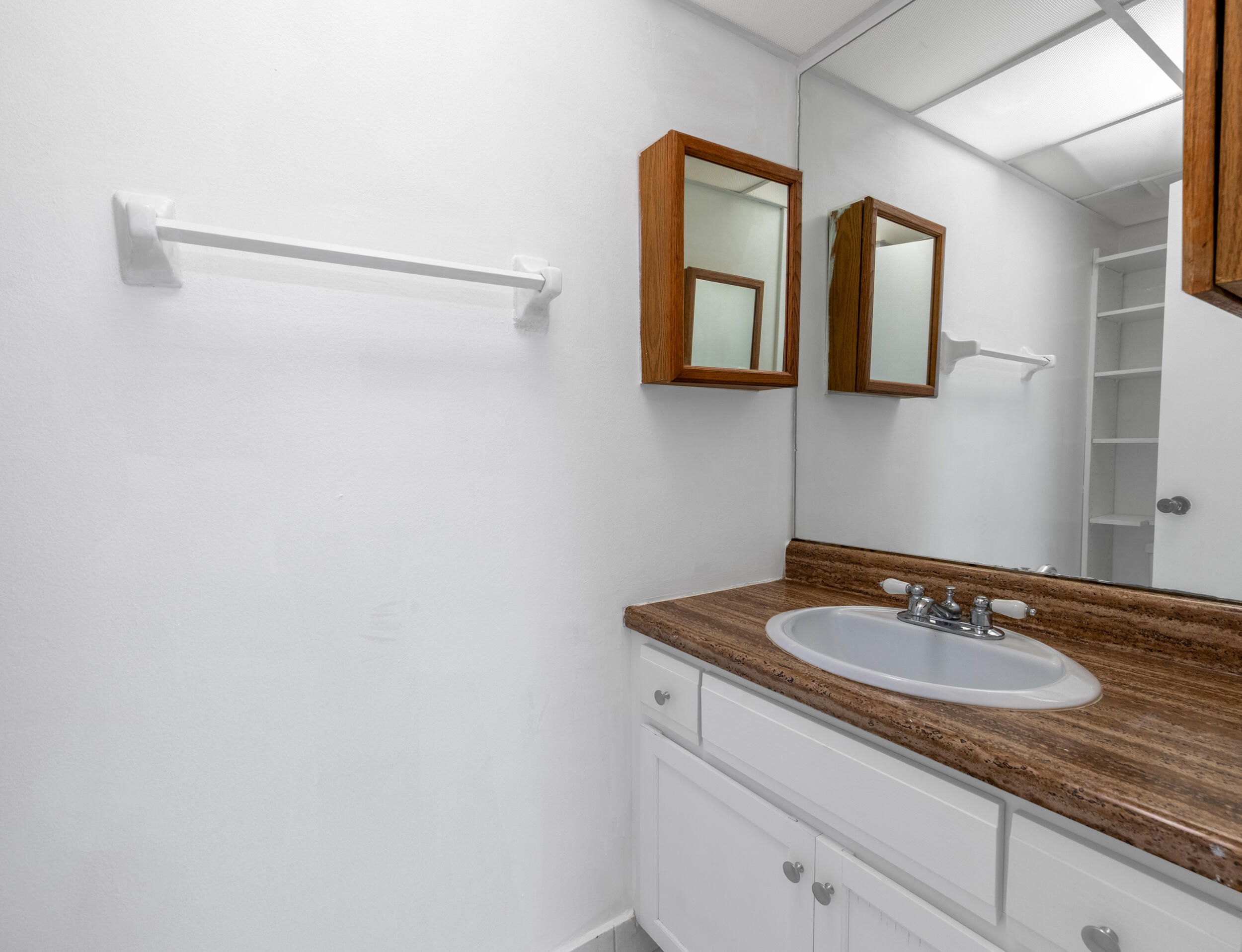 3660 Inverrary Drive, Unit 3Q Lauderhill, FL 33319 - Photo 9 of 35 a bathroom with a granite countertop sink and a mirror