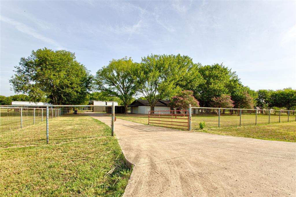 206 Americana Road Palmer, TX 75152 - Photo 2 of 40 Wide View From the Road Through Pipe Framed Fence & Gated Entry Up The Full Concrete Driveway.