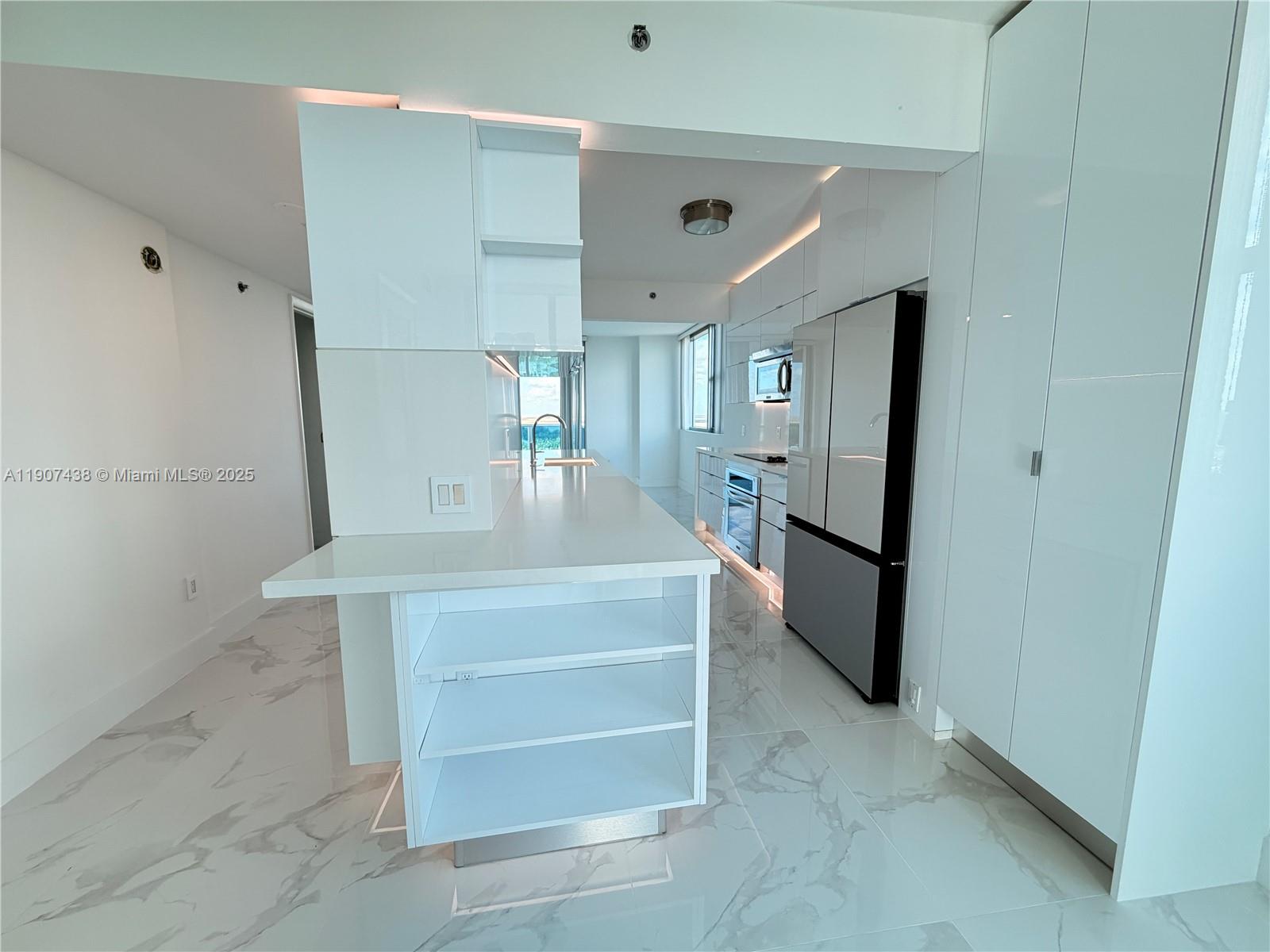 2641 North Flamingo Road, Unit 2208N Sunrise, FL 33323 - Photo 4 of 56 a view of kitchen with refrigerator cabinets and wooden floor
