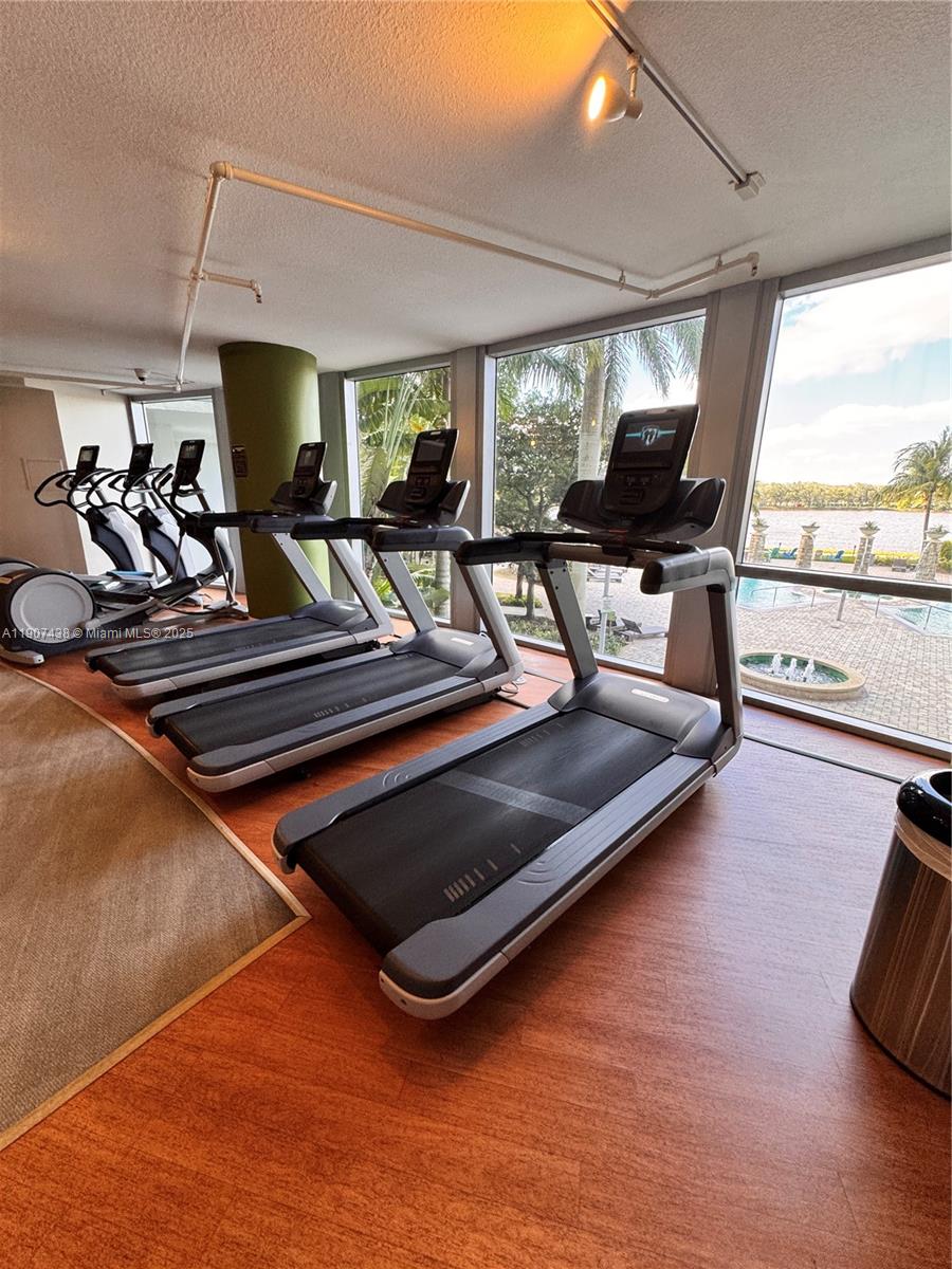 2641 North Flamingo Road, Unit 2208N Sunrise, FL 33323 - Photo 49 of 56 a living room with gym equipment and a large window