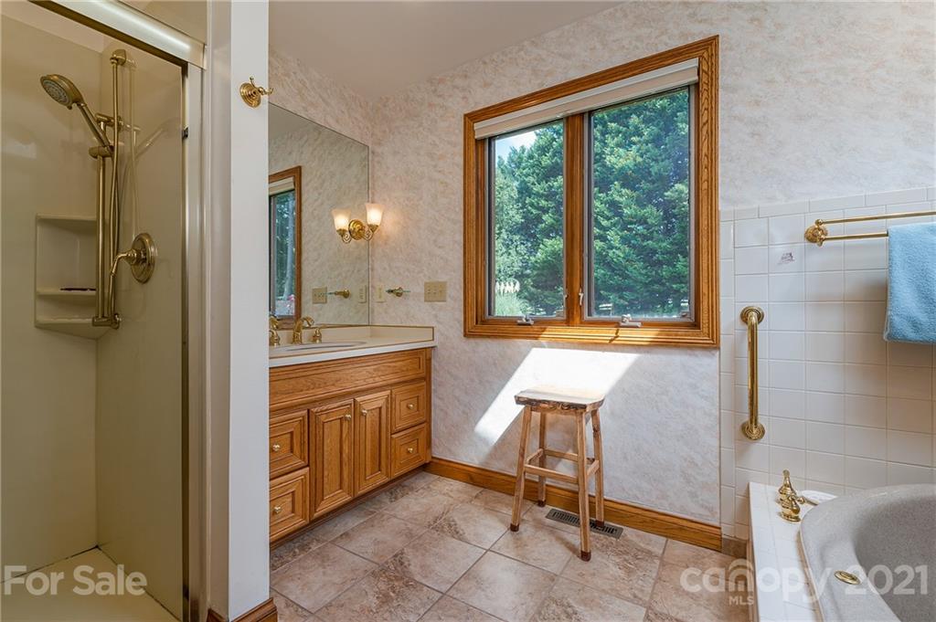 2101 Peniel Road Columbus, NC 28722 - Photo 33 of 48 a bathroom with a sink a mirror and a shower