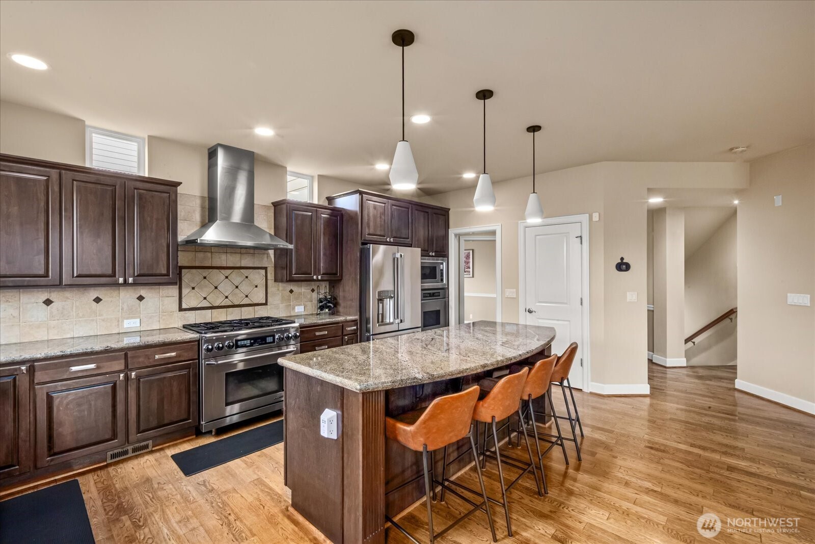 215 Ilwaco Place Southeast Renton, WA 98059 - Photo 14 of 40 a kitchen with stainless steel appliances granite countertop a kitchen island a stove and a sink