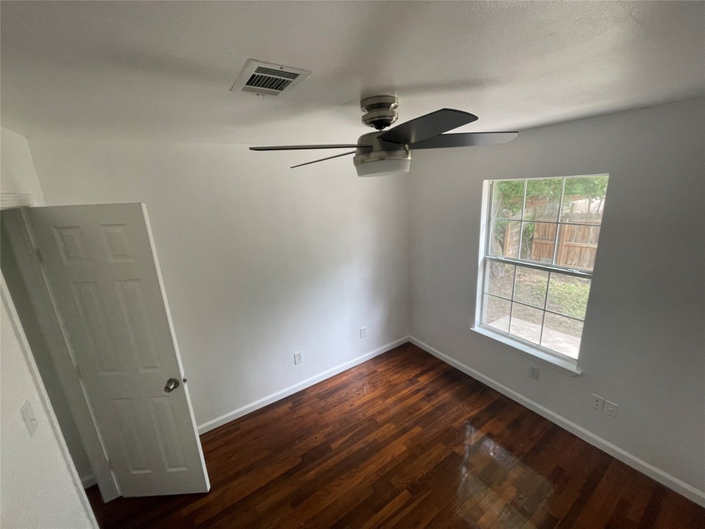 2808 Lyons Road, Unit A Austin, TX 78702 - Photo 13 of 13 an empty room with wooden floor cabinet and windows