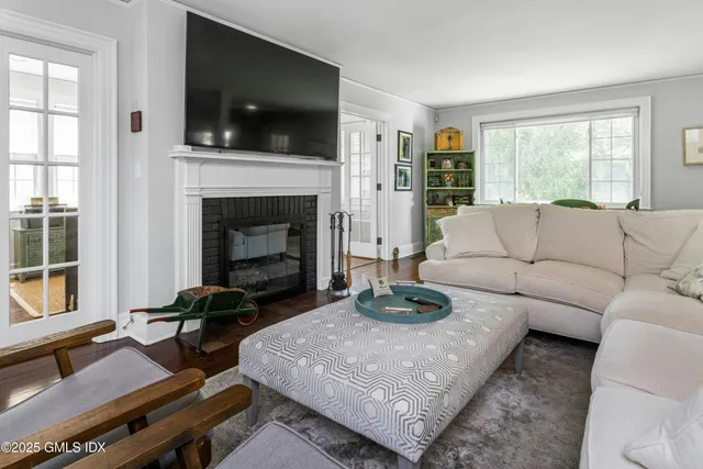 a living room with furniture a flat screen tv and a fireplace